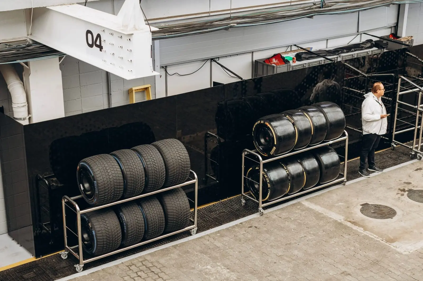 Racks of racing tires waiting in an open pit garage.