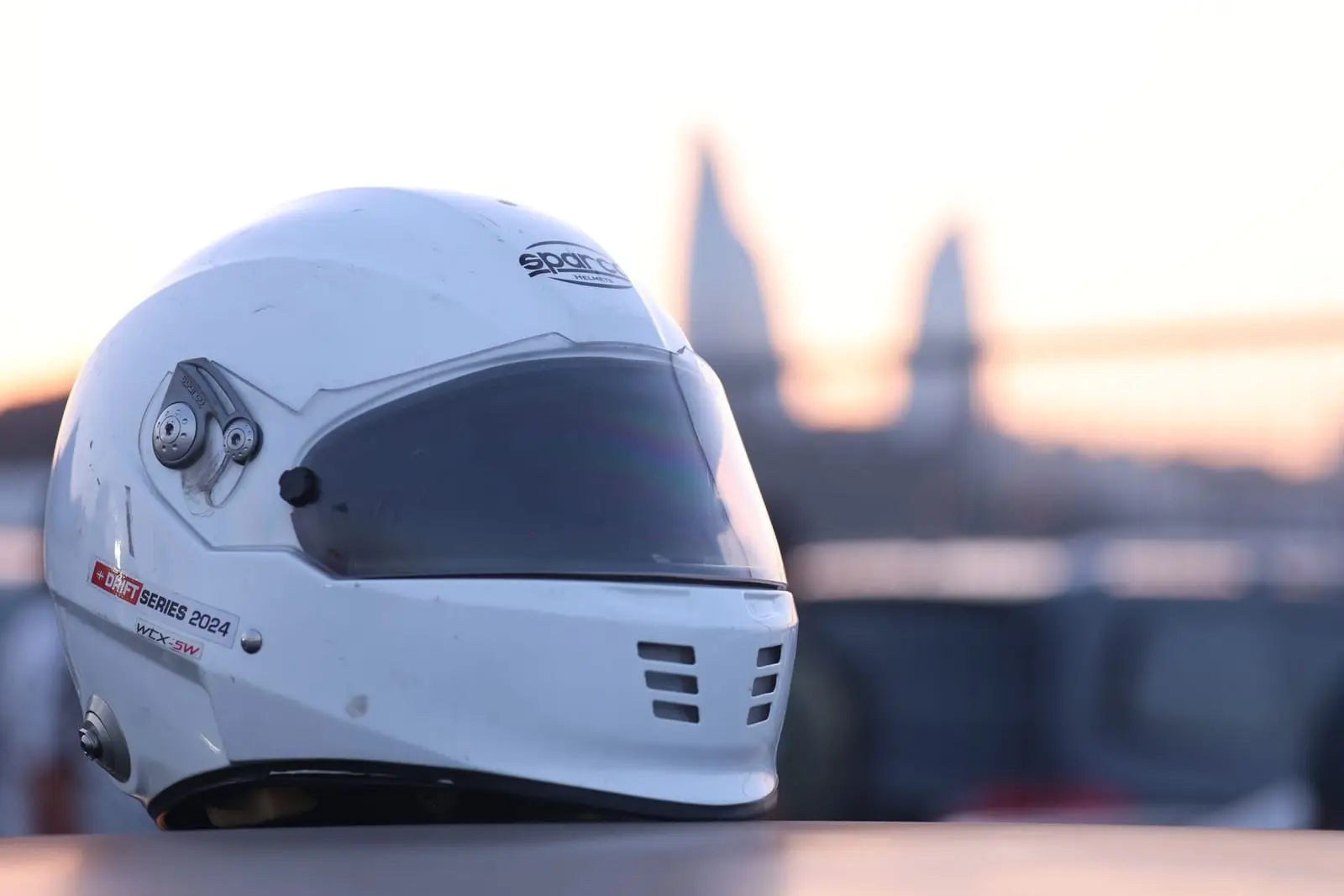 A white racing helmet resting at sunset.